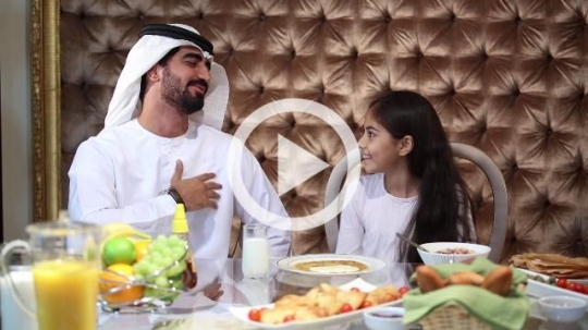 Arab father talking to his daughter during breakfast|