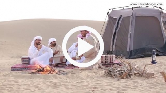 Group of men having coffee outside tent
