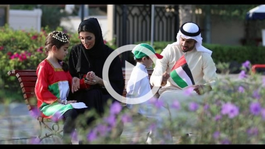 Arabian family sitting on the bench celebrating the UAE National Day|