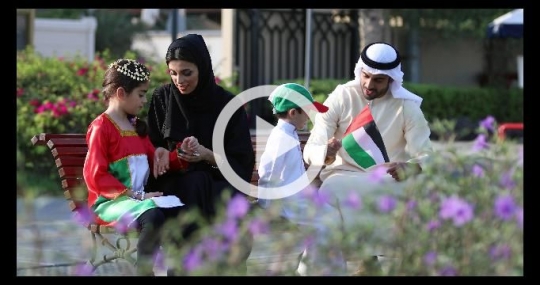 Arab family sitting on the bench celebrating the UAE National Day|