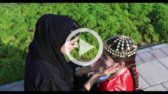 Arab mother and daughter sitting on the bench representing their country|