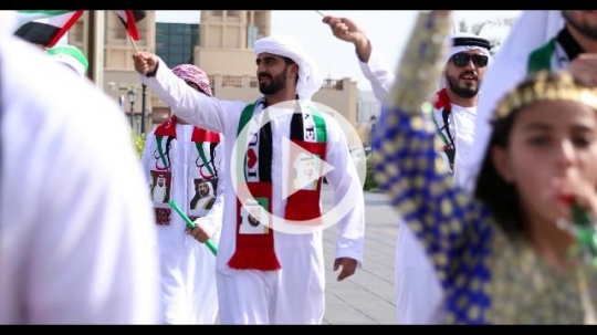 Arab family during a National Day parade representing their country|
