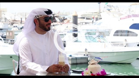 Middle Eastern man traditionally dressed sitting outside|