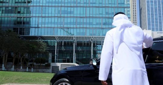 Middle Eastern Businessman fixes his kandoura and takes the call|-