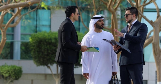 Businessmen standing together talking|-