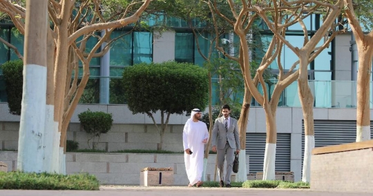 Middle Eastern Businessman walking with his colleague |-