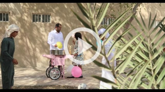Middle Eastern kids getting cotton candy from the man|
