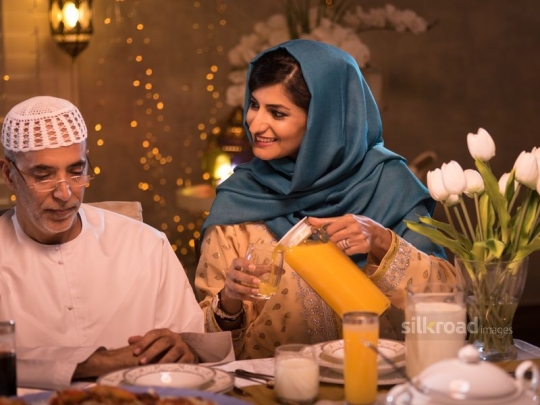 Woman holding jug of orange juice|-