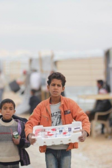 kid selling cigarettes in a refugee camp