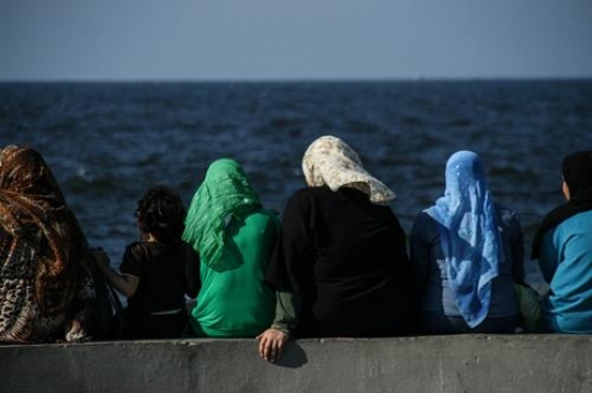 women sitting on sea wall of a