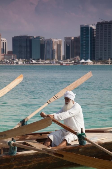 old man paddling a fishing boat