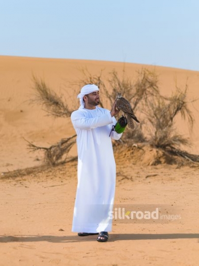 Emirati man carrying falcon