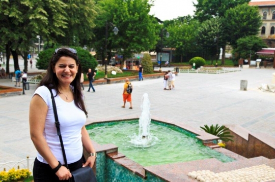 woman in green park with fount