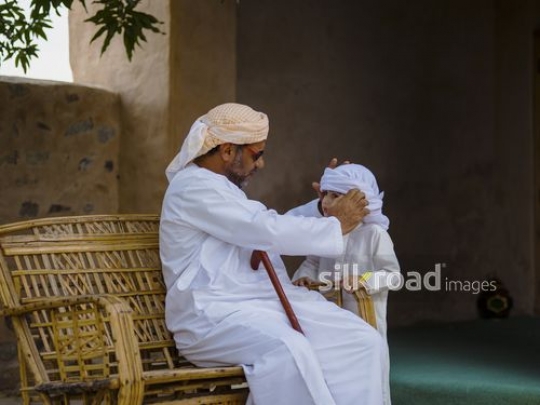 Old man fixing outfit of grandson|-