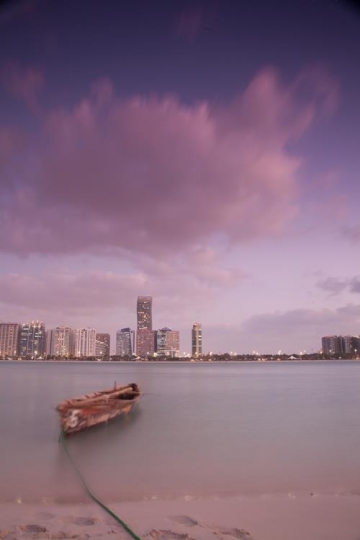 boat floating on the water in front a city shore