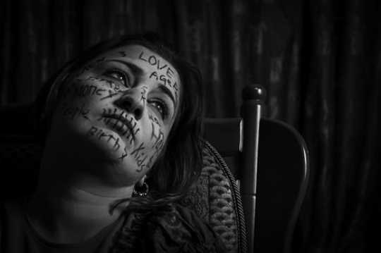 black and white image for woman with words written on her face