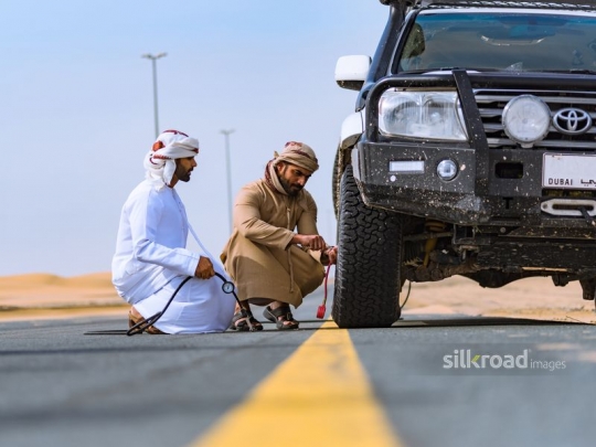 Men fixing flat tire