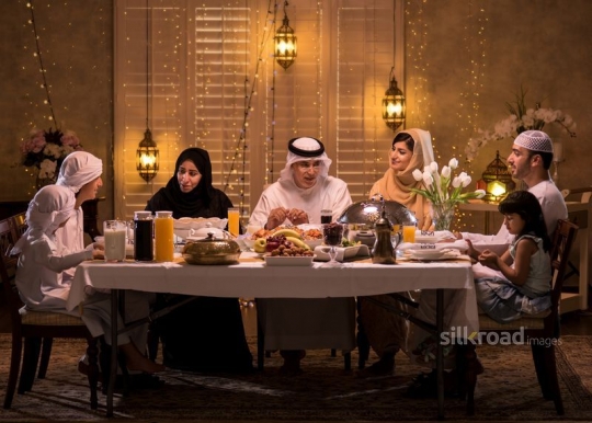 Family gathered over dining table|-