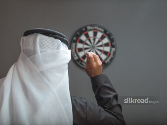 man aiming at dart board