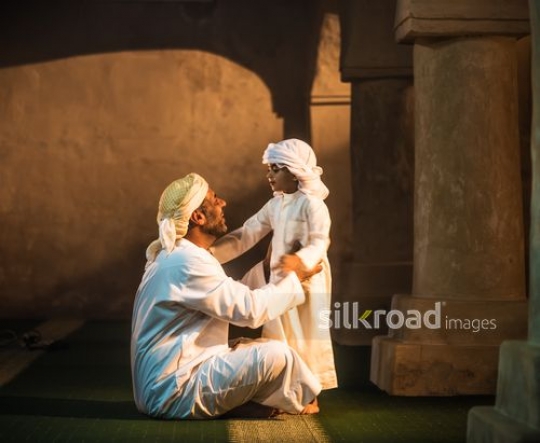 Little boy in conversation with grandfather at the mosque|-