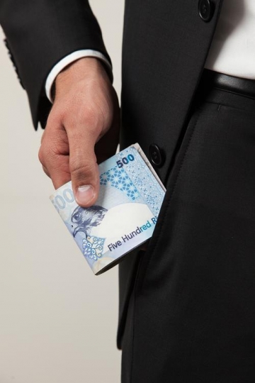 businessman putting money in his trouser pocket
