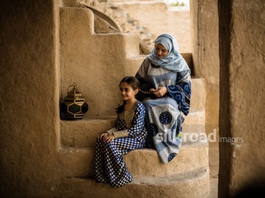 Girl siting with mother on the stairs|-