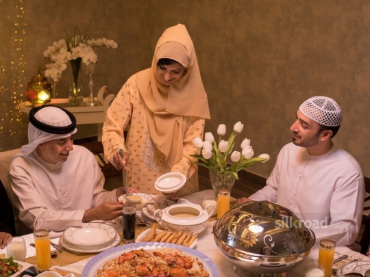 Mother serving soup to family|-
