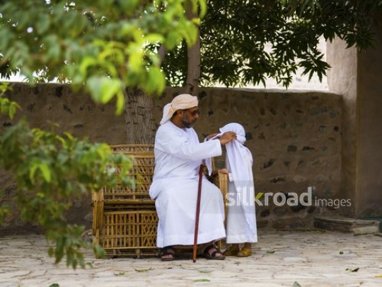 Old man fixing outfit of grandson|-