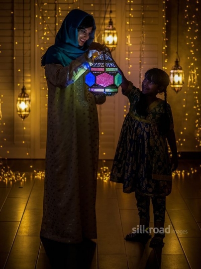 Mother and daughter holding lantern|-