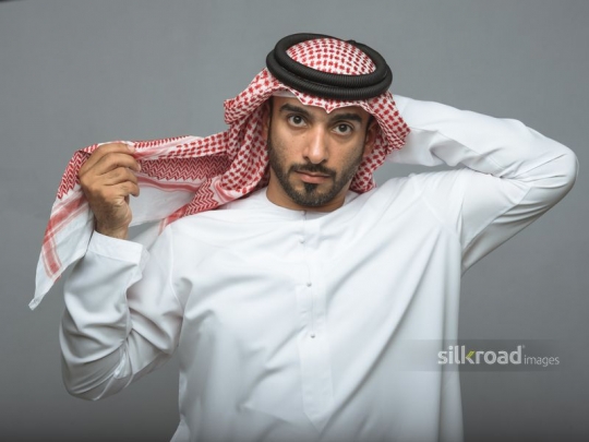 Arabian man fitting his traditional head cover