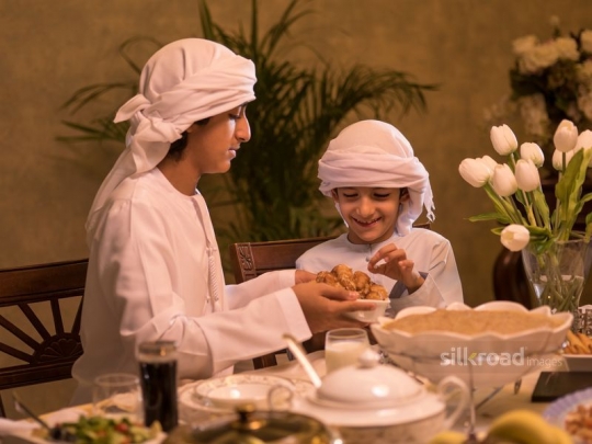 Boy taking arabic sweets|-