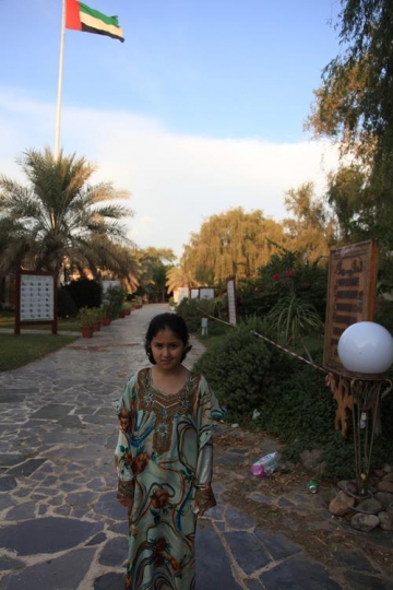 little girl standing in a park facing camera