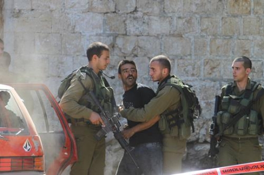 israeli soldier arresting palestinian