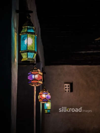 Colourful lanterns aligned on the wall|-