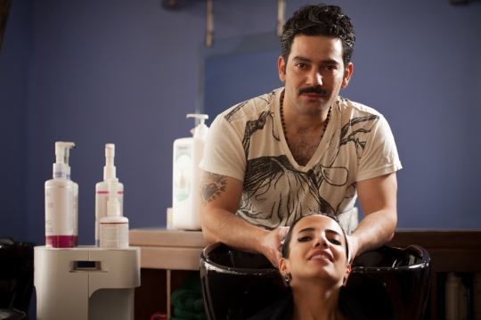 Middle Eastern hair stylist washing the woman's hair|