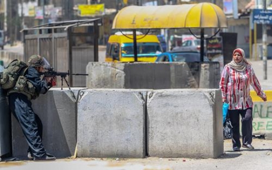 Israeli Soldier with weapon and Palestinian girl
