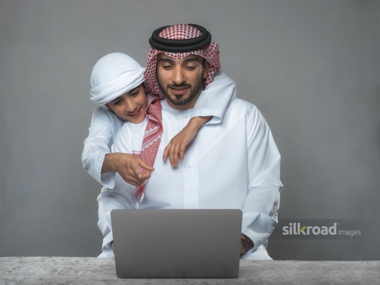 father and son enjoying their time behind the laptop