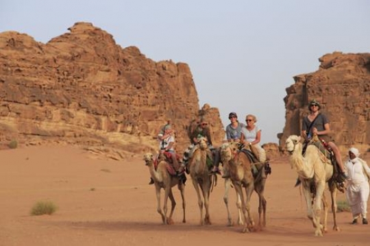 tourists riding a camels in wadi rum