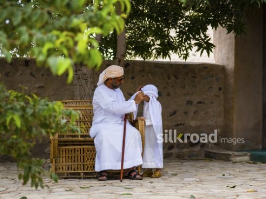 Oldman fixing costume of his grandson|-