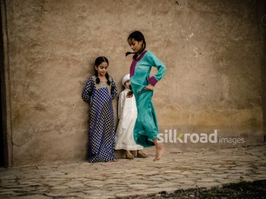 Girl playing with brother and sister outside|-