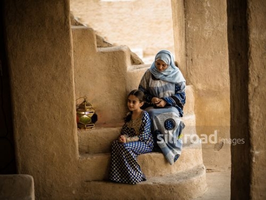 Woman making braids for daughter|-