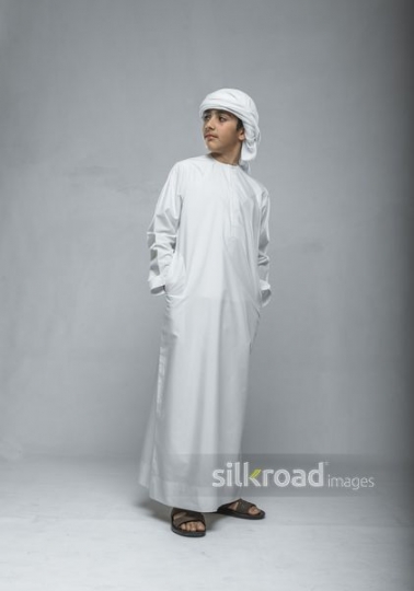 Little boy looking sideways with hands in pockets