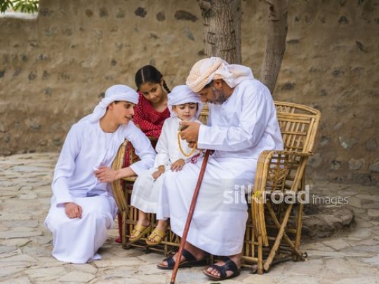 Grandfather showing mobile to kids|-