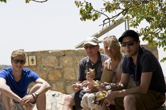 group of tourist eat sandwich while they are taking a rest