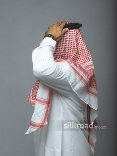 Side view of an arabian man fitting his head cover