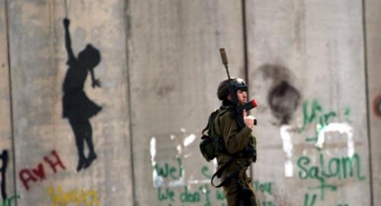 israeli soldier stand near the separation wall