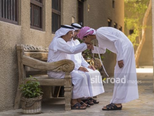Arab son kissing grandfather hand|-
