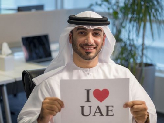 Arab business man celebrating the UAE National Day at the office|