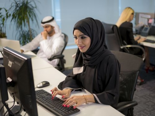 Business woman sitting by her desk working|