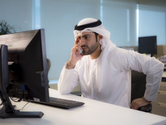 Business man sitting by his desk and thinking while looking at the computer|